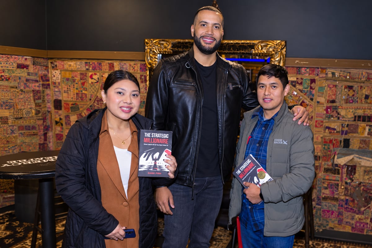 Two readers holding copies of The Strategic Millionaire with Armando